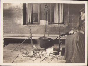 Femeie cu ceaun pe foc de lemne, cca 1918
