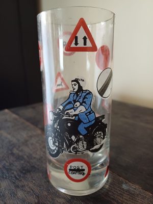 Pahar decorat cu milițian pe motocicletă și semne de circulație, fabricat din sticlă în România în perioada comunistă
