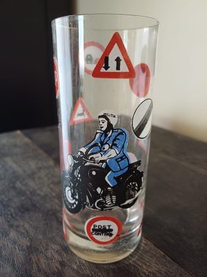 Pahar decorat cu milițian pe motocicletă și semne de circulație, fabricat din sticlă în România în perioada comunistă