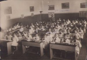 Elevi în sala de clasă, cu învățătoarea, județul Ilfov, perioada interbelică