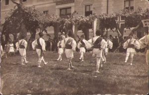 Tineri în port popular românesc, cu zurgălăi prinși sub genunchi, joacă în fața căminului studenților, Transilvania, anii 1930