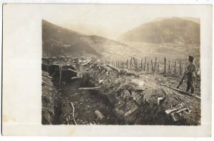 Soldat austro-ungar cu pușcă, probabil din regiment din Transleithania, lângă tranșee cu rețea de sârmă ghimpată pe mai multe rânduri de pari, Marele Război
