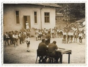Pionieri români la o școală de țară, cu tobe, goarne și steaguri