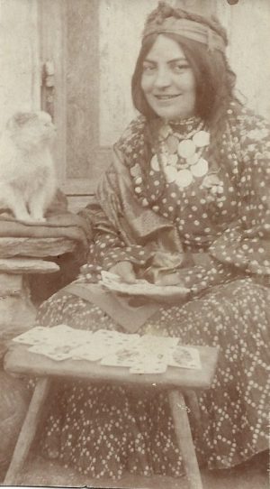 Țigancă cu salbă de galbeni dând în cărți sub privirea unei pisici, cca anii 1910-1920