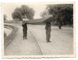 Transportarea de către 2 oameni, la umăr, a bărcii de asalt MAN model Lt-col Stan Vasile, brevet regal român nr 29534/1939, fabricată la Aquila Româno-Americană din București