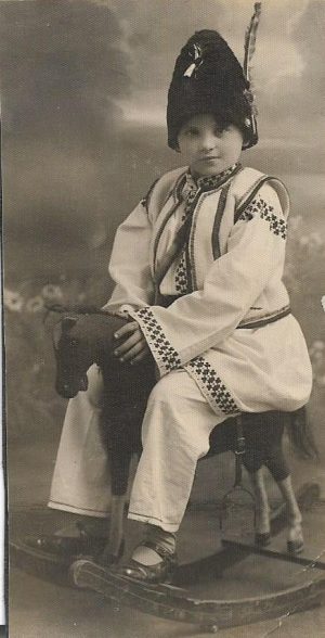 Copil în port popular, pe căluț, membru al trupei de circ a lui Garabet Artin Cuiumgian alias George Ionescu, proprietar și actor de circ, România, perioada interbelică