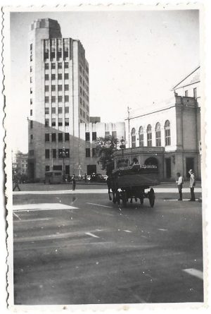 Căruță plină cu sifoane și polițist în intersecție în fața Teatrului Național și a Palatului Telefoanelor din București, perioada interbelică