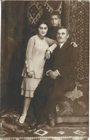 Fotografie de familie în decor cu covoare cu model neoromânesc, perioada interbelică